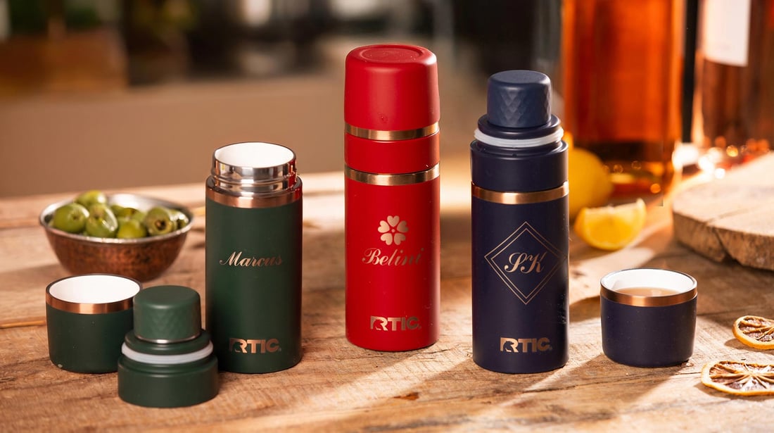 A group of RTIC's 8oz Happy Hour Flasks featuring engraved personalization sitting on a table.