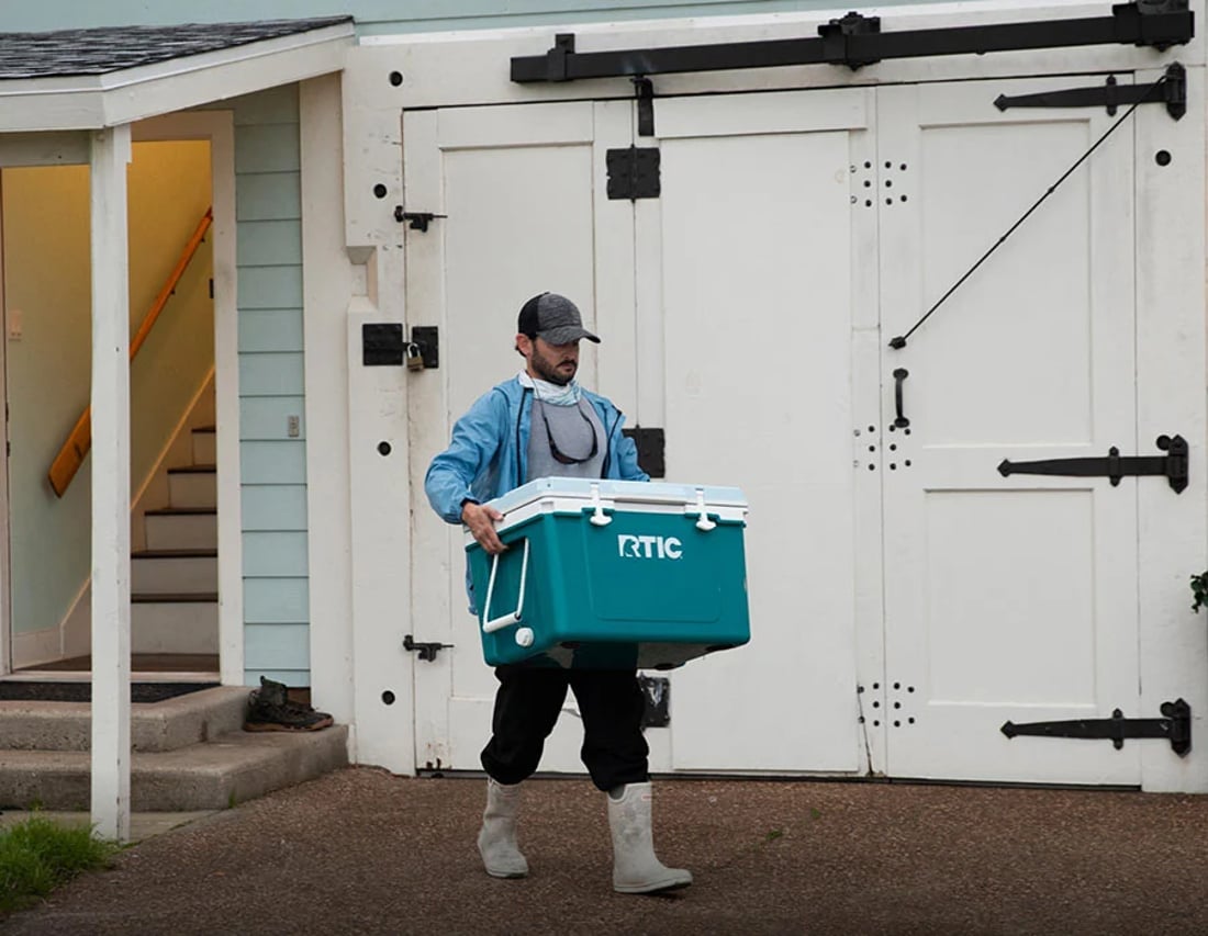 Man carrying Blue RTIC 52QT Ultra-Light Cooler