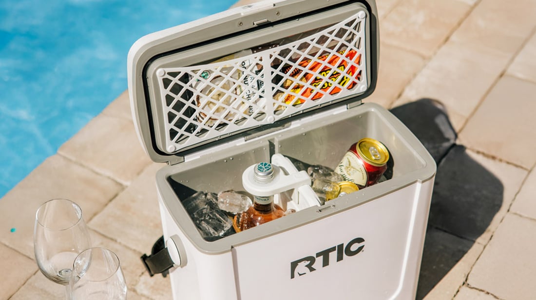 white RTIC 16qt Road Trip Cooler filled with ice and drinks next to the pool