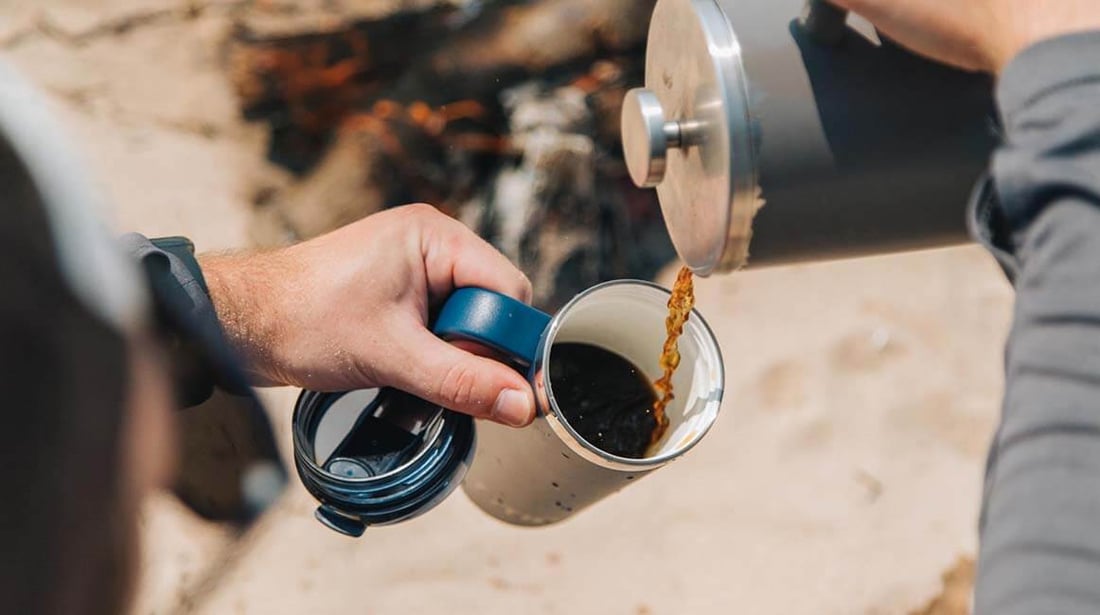 Hot coffee being poured into a blue RTIC Road trip travel mug