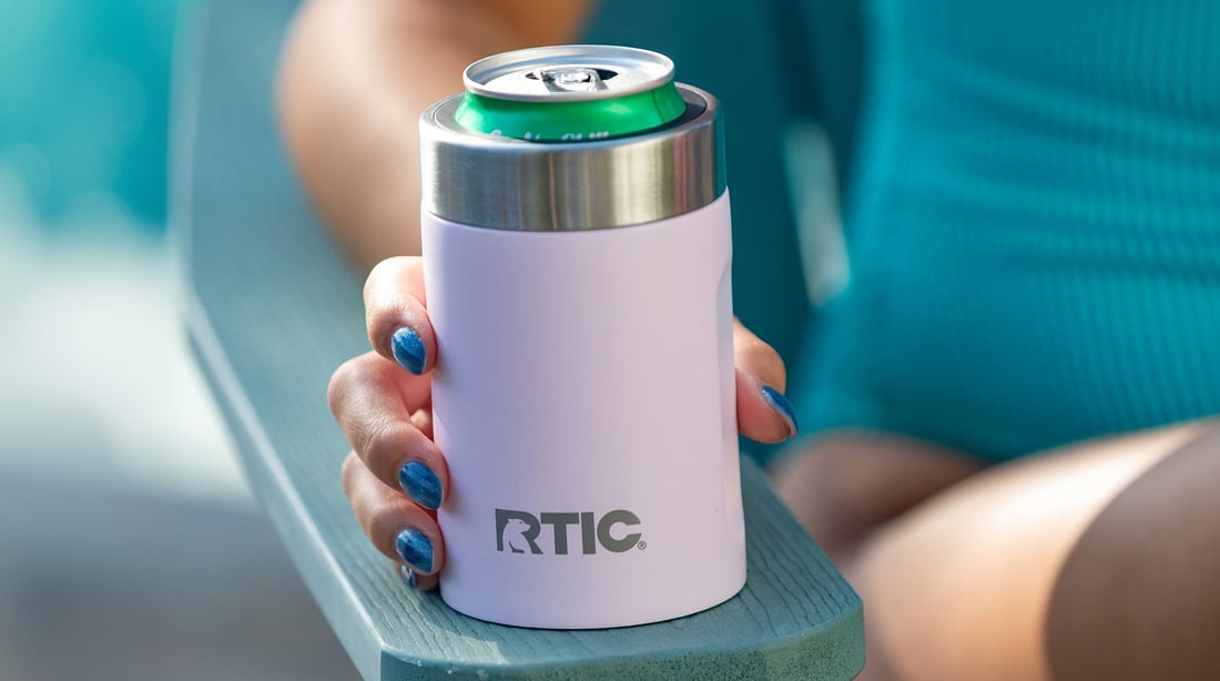 Close-up image of a woman holding a white RTIC Ultimate Can Cooler in a chair.