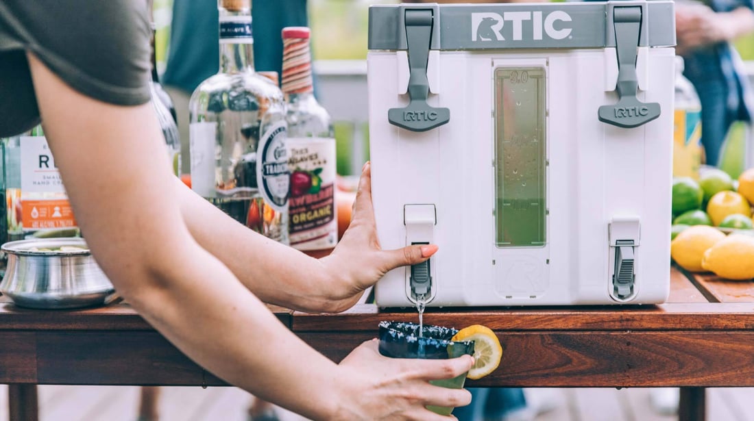 Dispensing drinks on the deck from a white RTIC Halftime Cooler.