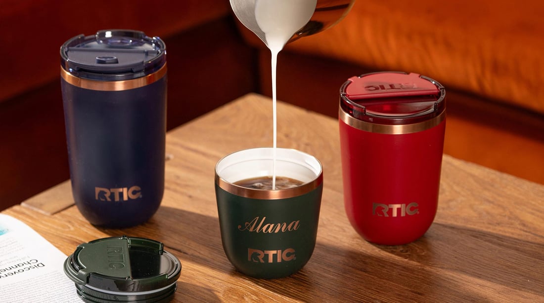 Cream being poured into coffee in a green RTIC Daybreak Coffee Cup.