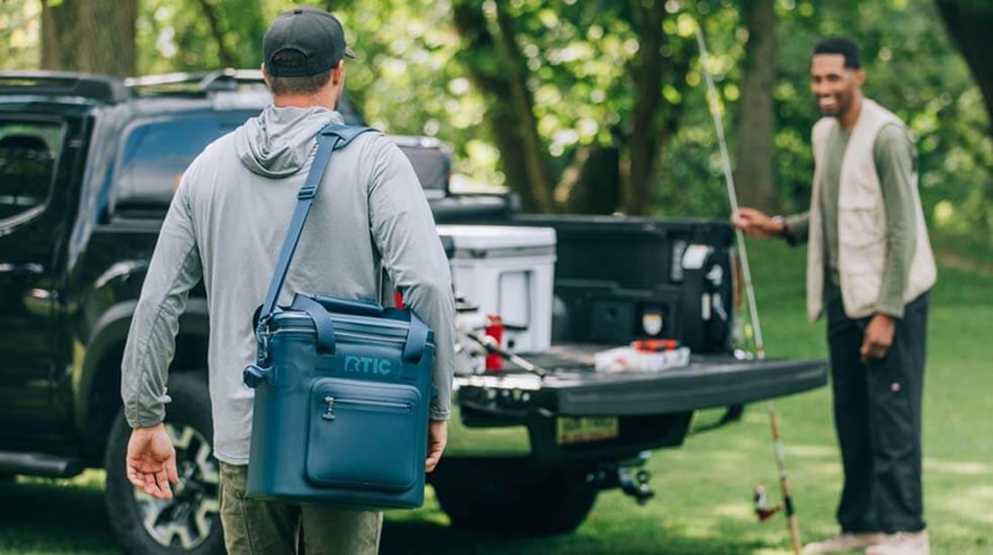 Man carries an RTIC Ultra-Tough Soft Cooler Pro outdoors using the shoulder strap.
