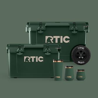 RTIC dark green cooler collection with two hard coolers and three insulated drinkware pieces on a green background
