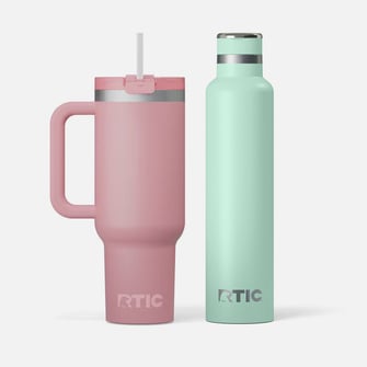 RTIC Drinkware on a grey background, a pink one with handle and straw and a slim, tall teal bottle.