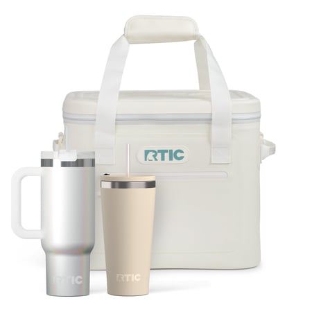 Ivory colored RTIC soft cooler, white glitter tumbler with handle and straw, and tan tumbler with straw.