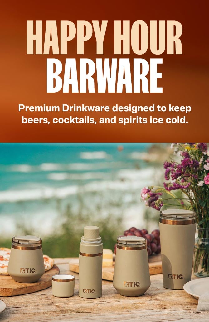 RTIC brand barware collection on a wooden table outdoors, featuring insulated cups and a shaker in a tan color with a beach background.