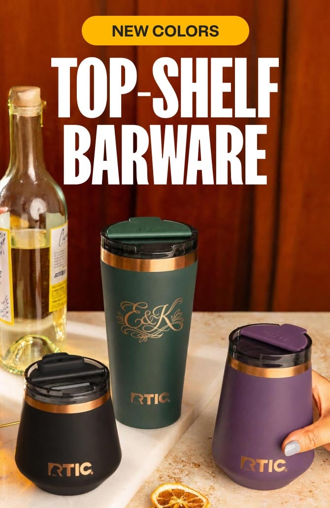 A close-up of a group of RTIC Barware on a table with a bottle and cocktail garnishes.