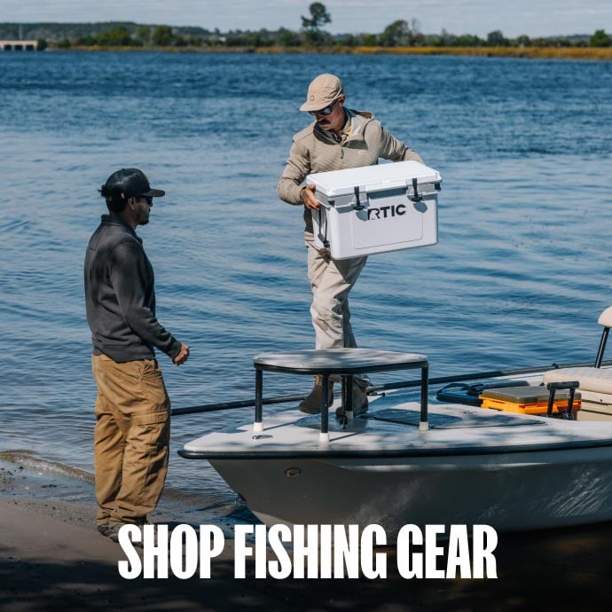 Friends fishing on a boat with a white RTIC hard cooler.