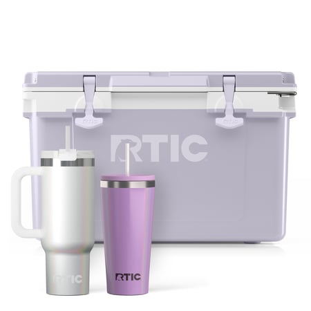 Light purple RTIC hard cooler with white glitter tumbler with handle and straw and purple tumbler with straw.