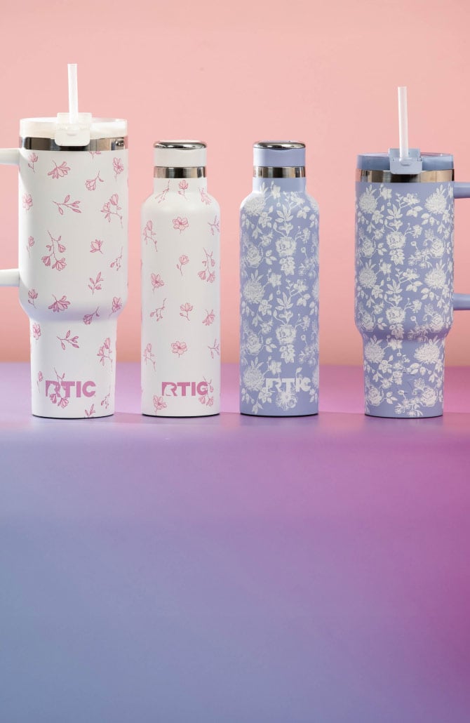 Assorted RTIC drinkware featuring pink and white floral patterns, including slim bottles and large handled cups with straws.