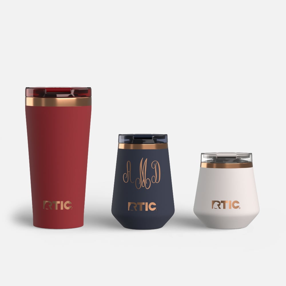 A dark red Happy Hour Pint Tumbler, a dark grey Happy Hour Wine Tumbler personalized with the initials AMD, and off-white Happy Hour Lowball Tumbler