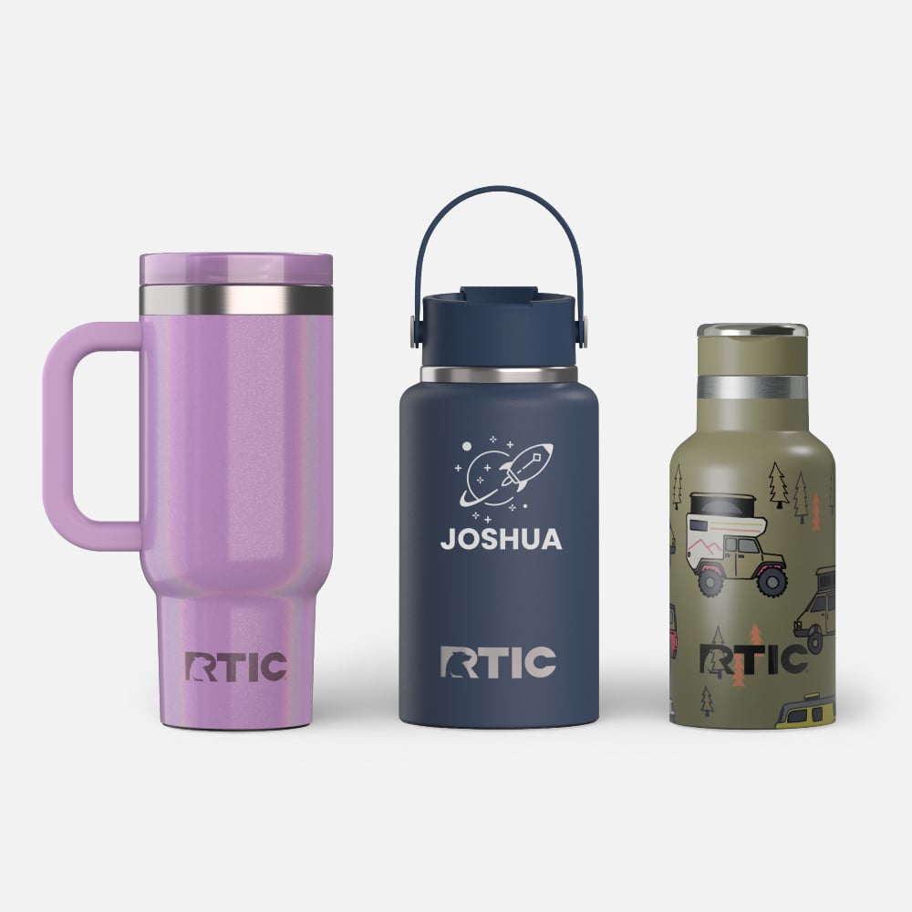 Three RTIC kids drinkware pieces: glittery purple handled tumbler, navy bottle with Joshua and rocket graphic, and green camper-print bottle.