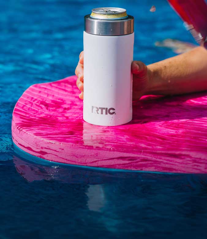 Person enjoying a white RTIC Ultimate Can Cooler in the pool.