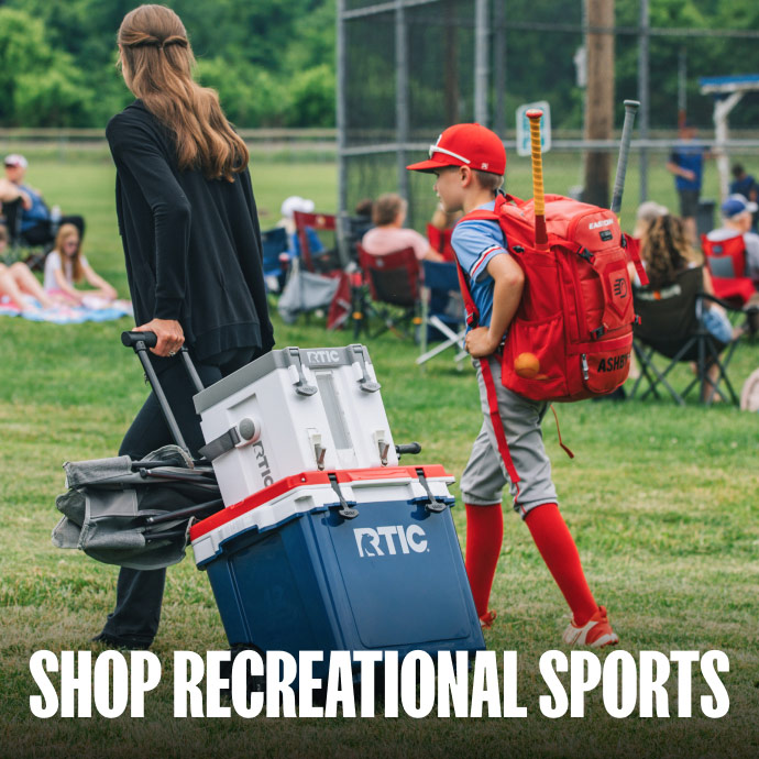 A family pulling a white RTIC wheeled cooler to the baseball field.