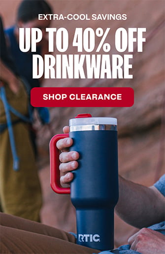 A person holding a patriot-colored RTIC Road Trip Tumbler in their hand.