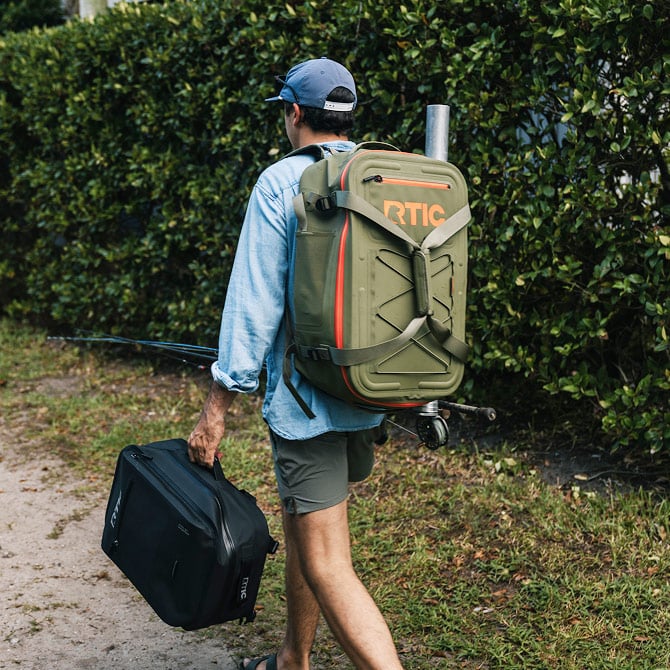 Man walking on a trail, carrying an Ultra-Dry Backpack on his back.