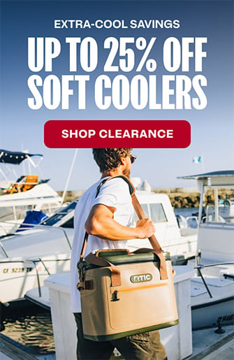 Man walking with a tan RTIC Ultra-Tough Soft Cooler on a boat dock.